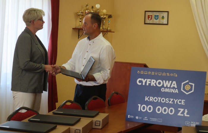 zdjęcie wójta i p. dyrektor z Krotoszyc przekazującego laptopa