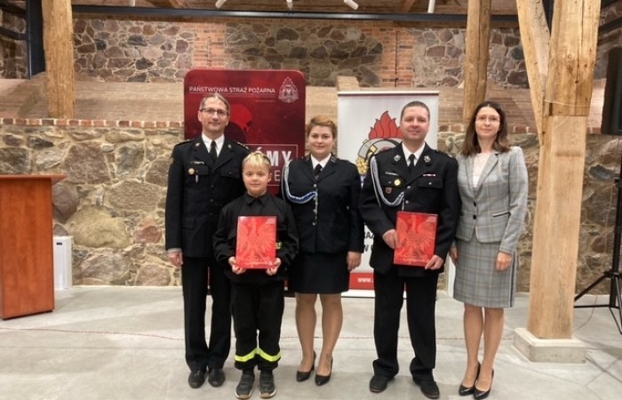 zdjęcie przedstawicieli drużyn strażackich z promesą