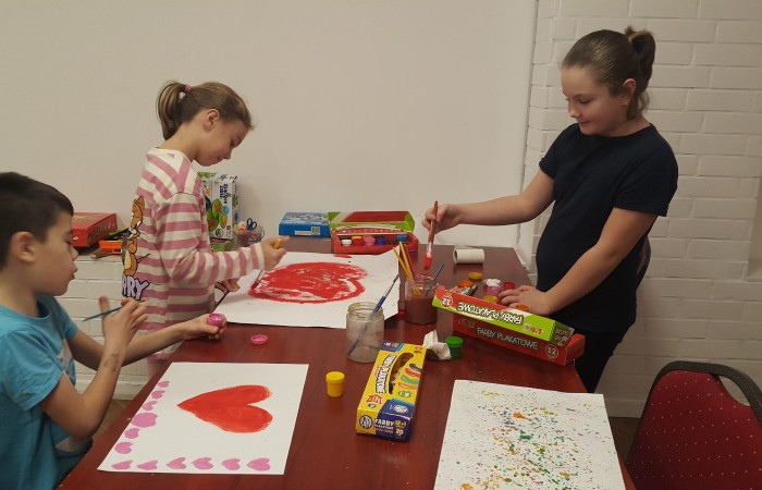 Dzieci malują serca farbkami