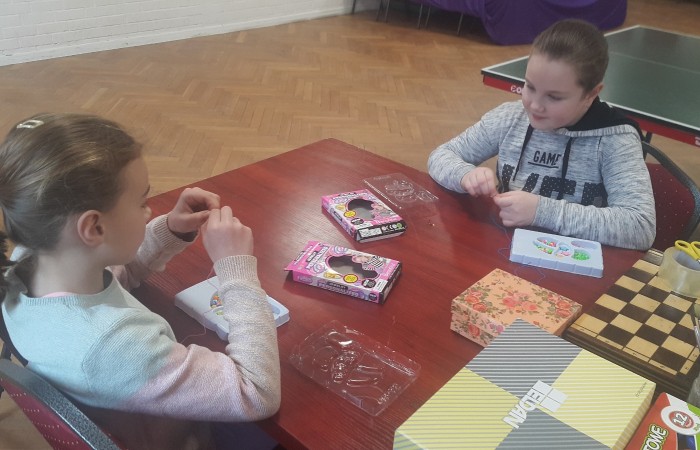 Dzieci nawlekją koraliki