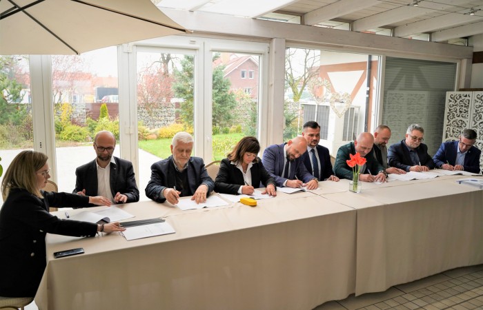 Podpisywanie dokumentów przez uczestników spotkania przy stole