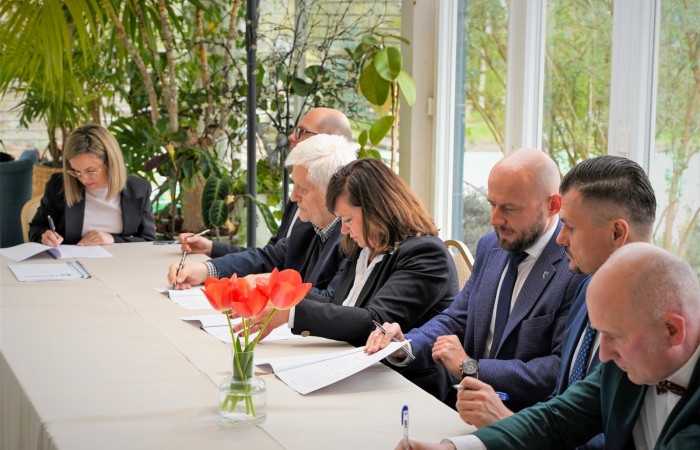 Podpisywanie dokumentów przez uczestników spotkania przy stole