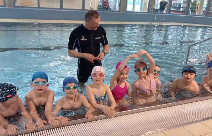 zdjęcie dzieci na basenie z instruktorem pływania