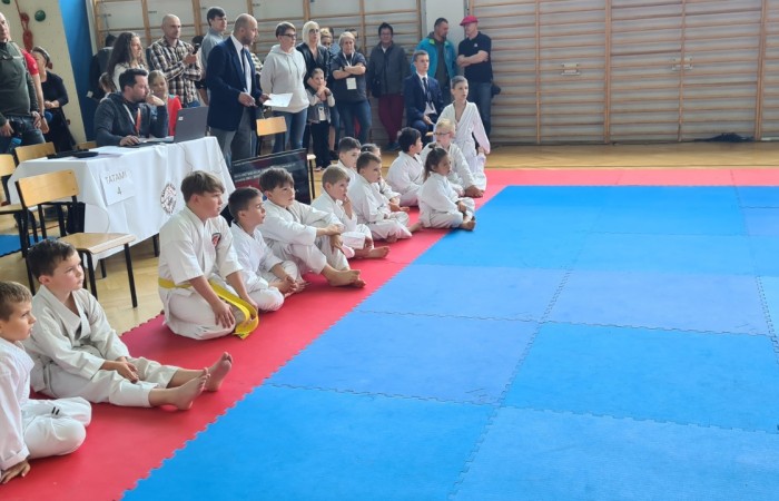 zdjęcie uczestników turnieju siedzących na macie